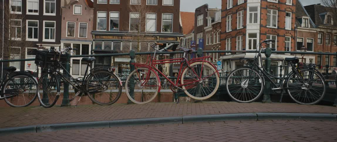 A row of bicycles on a street along a canal in Amsterdam