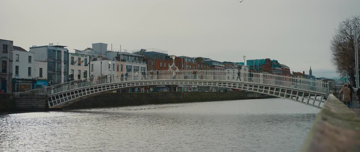 Pedestrians crossing the Ha'penny Bridge over the River Liffey in Dublin, Ireland
