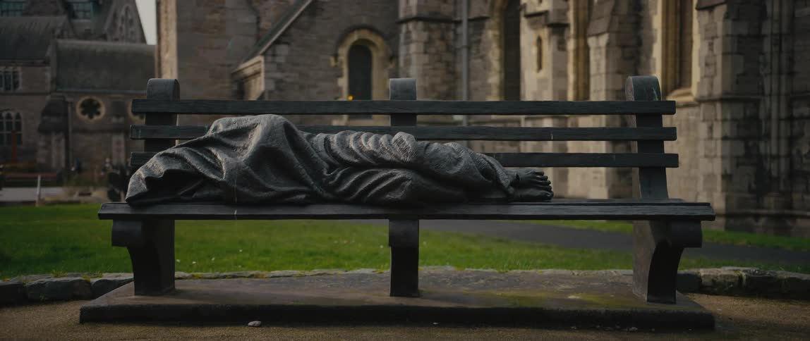 A statue Jesus the Homeless on a park bench outside of Christ Church Cathedral in Dublin, Ireland