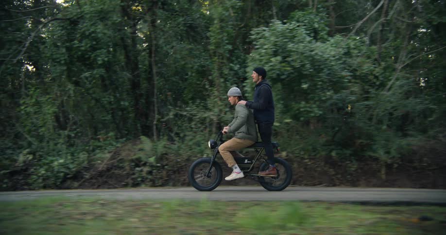 Two people ride on an electric bike together