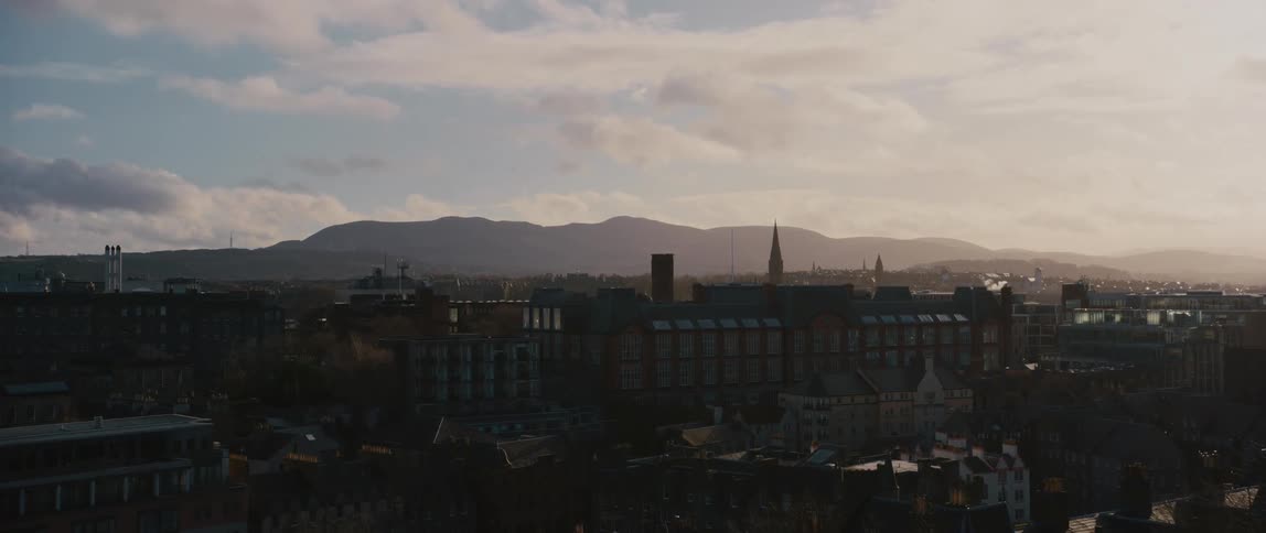 Aerial view of Edinburgh, Scotland at sunset with mountains in the distance