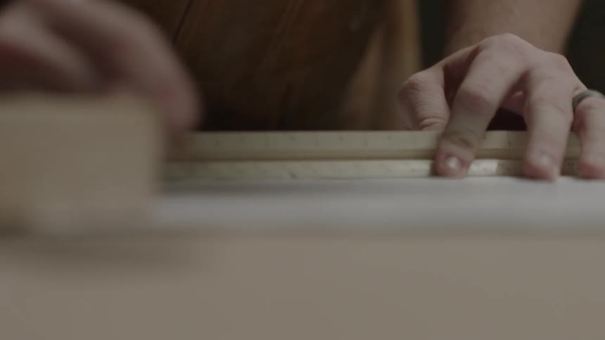 Person using a ruler to help draw up their plans