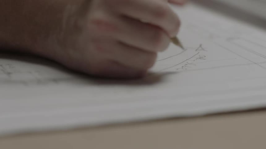 A hand is writing on a diagram