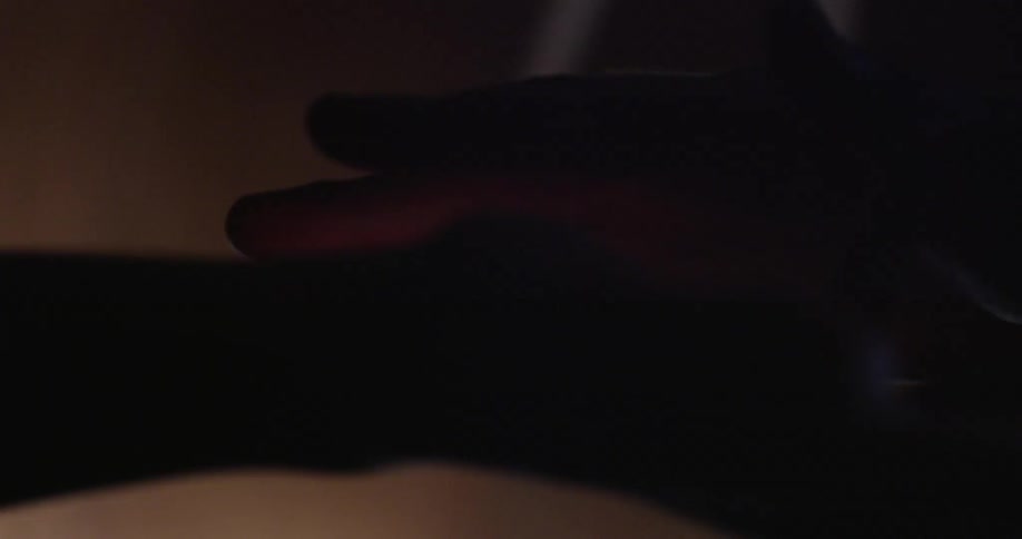 Two hands touch each other in a dark area