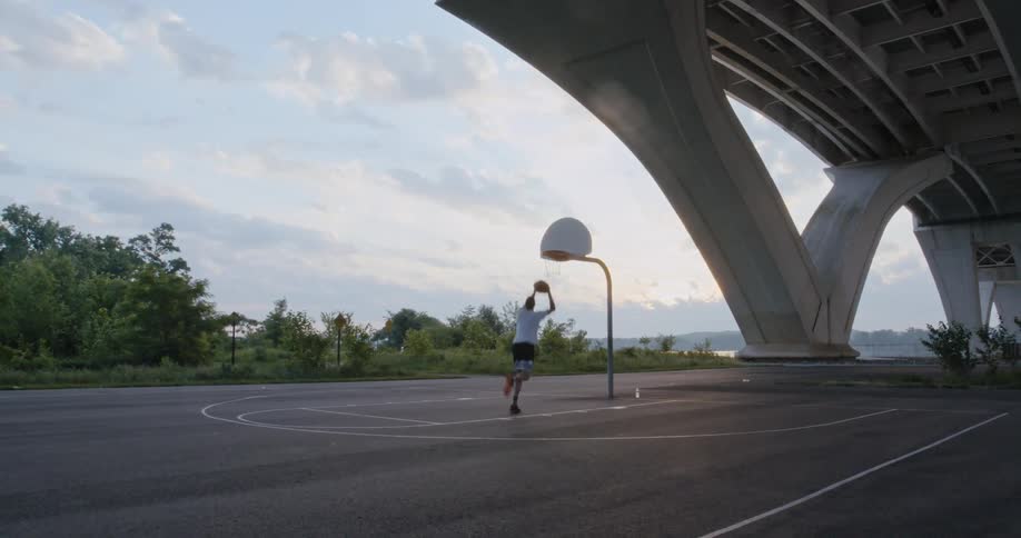A man drives the basketball to the hoop