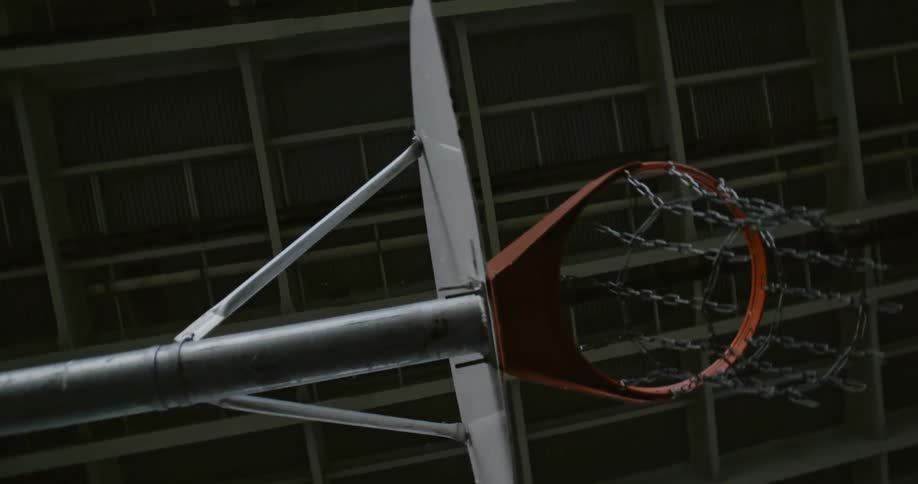 A basketball hoop with chain net under a highway overpass
