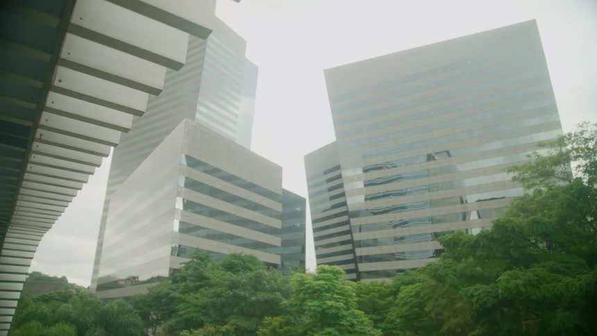 The rochaver corporate towers with green trees in front and reflections on the facade