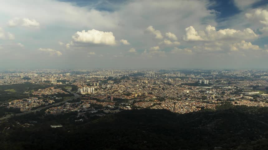 Heavy clouds cast a shadow as they move over cityscape of large metropolis.