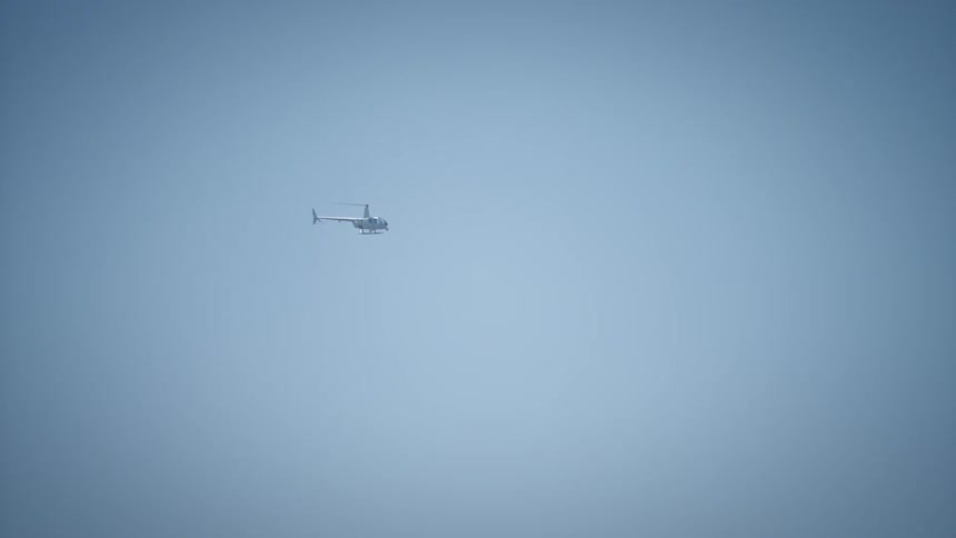 A helicopter flying in a clear blue sky