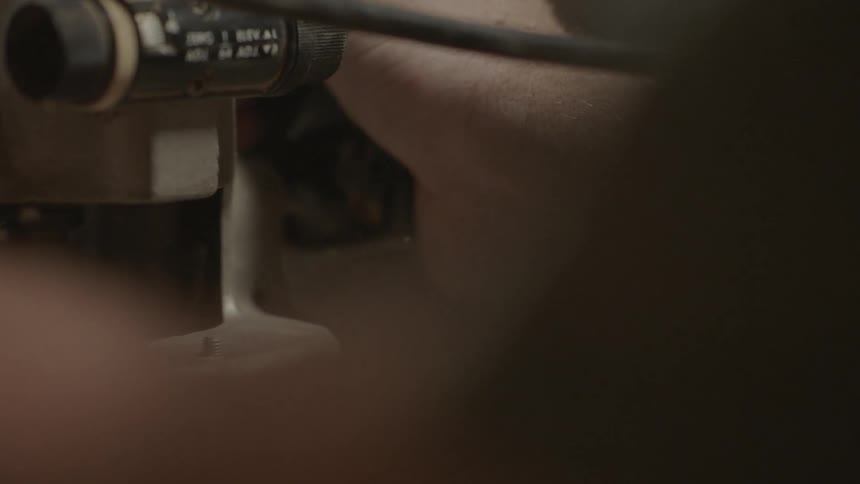 A person saws something and shavings fly around