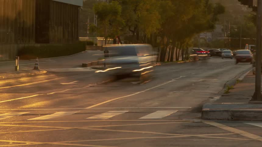 Cars vans and motorcycle drive on city highway at dusk