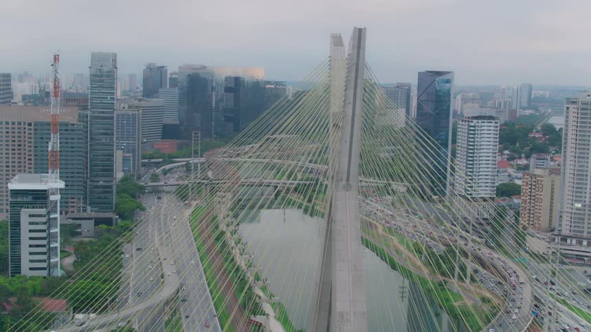 Cars traveling over a large suspension bridge in a city