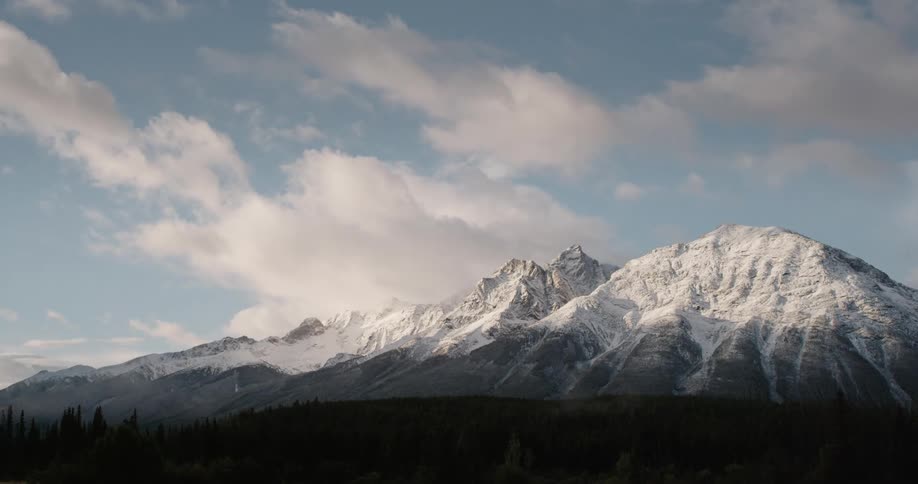 Clouds floating over a snowy mountain range on a winter day
