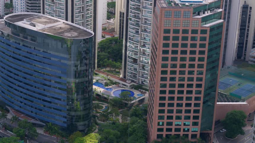 Vehicles driving past high rise office buildings and apartment buildings in a city