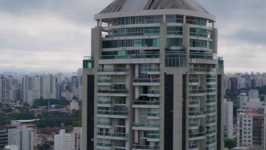 An aerial view of an airplane flying past apartment buildings and high rise offices in a city