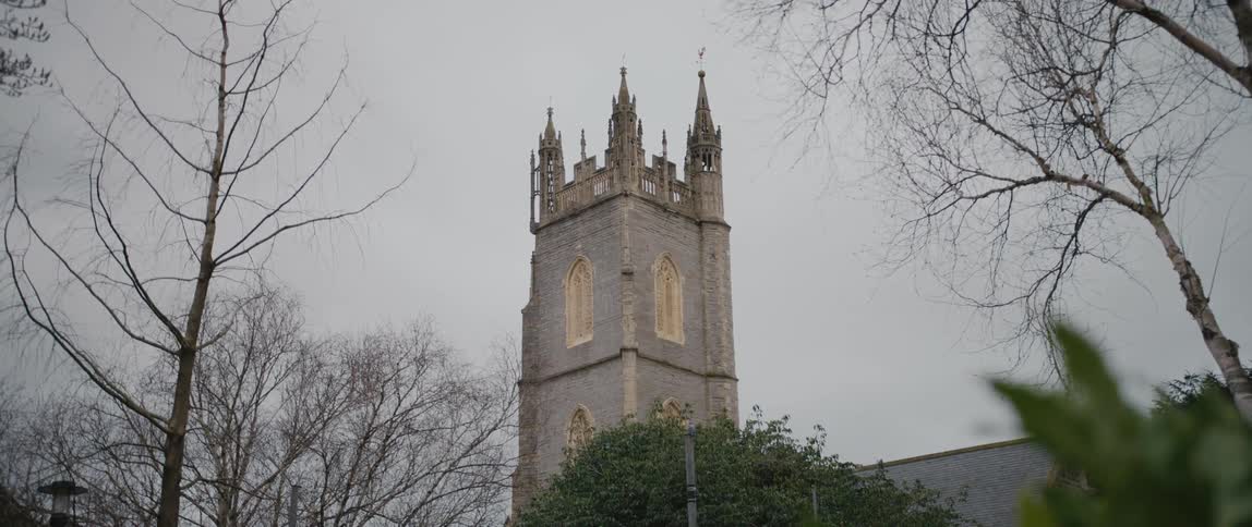 A large tower with steeples on an overcast day