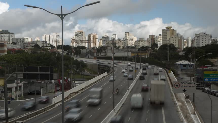 Traffic travels along a freeway through a metropolis during rush hour.
