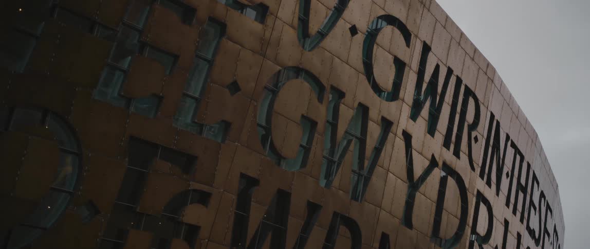 Large block letters cover surface of structure under an overcast sky