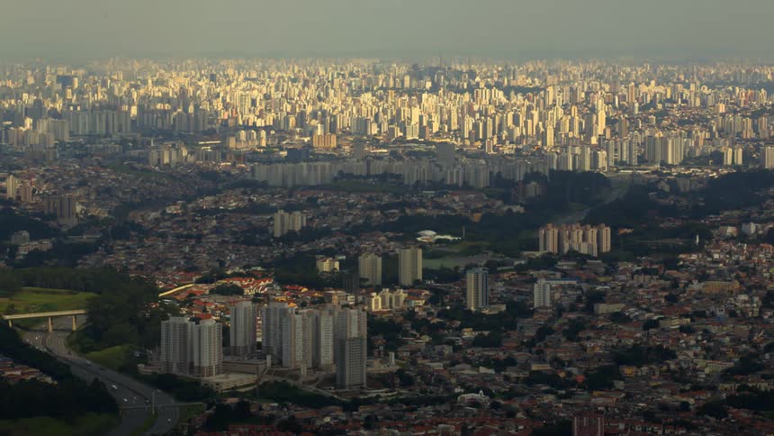 Moving clouds cast shadows over urban landscape of Brazil's largest city.