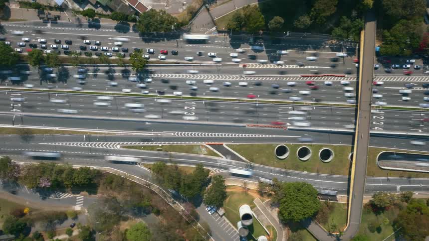 Aerial timelapse show vehicles travelling on the freeway past the trees and buildings