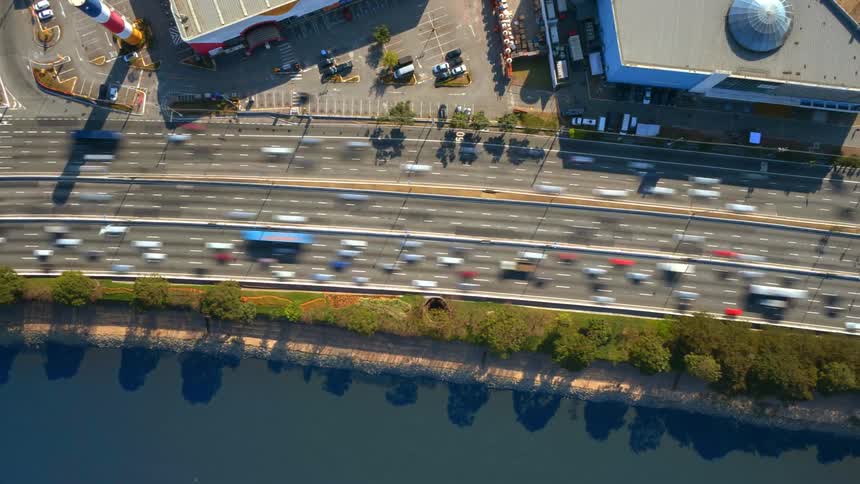 Time lapse of vehicles driving by a river in a city