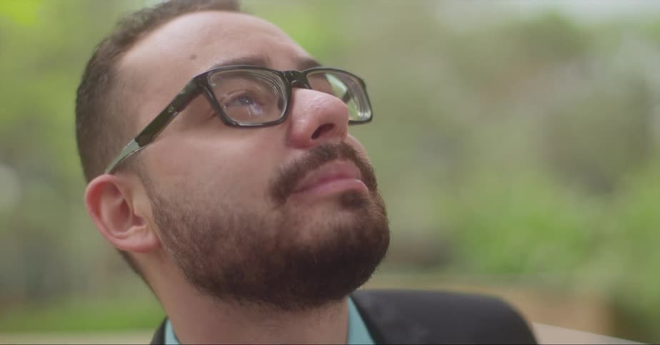 A man smiles softly with his head tilted upwards