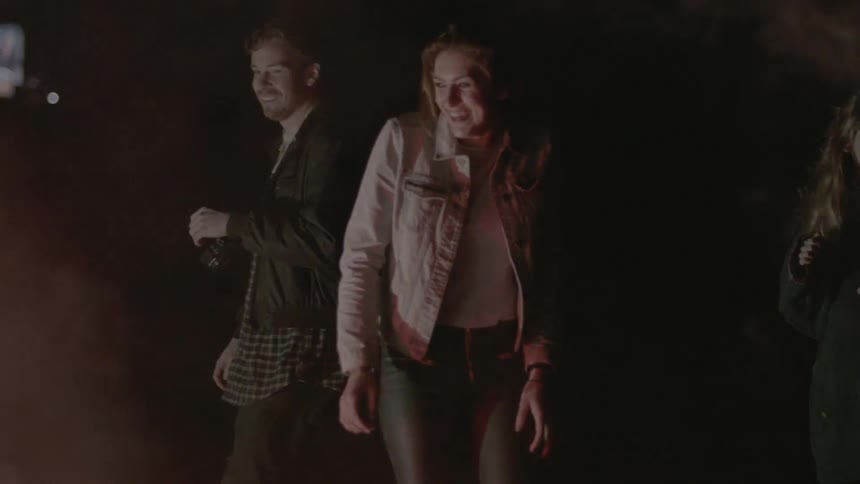Friends watch fireworks on the ground at night