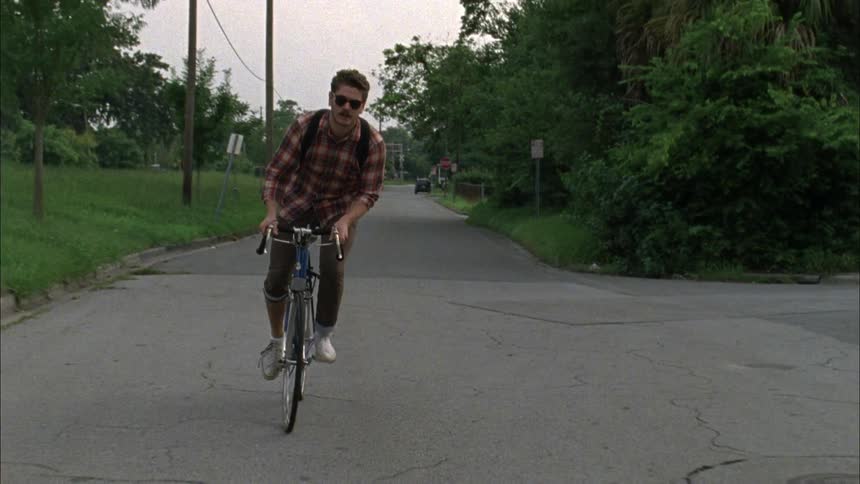A man is riding his bike on a small road