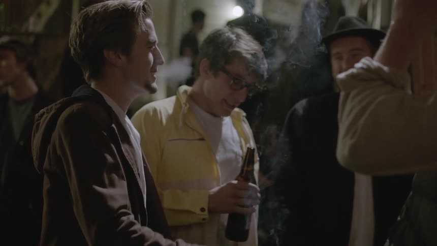 People are at a party outside smoking and talking