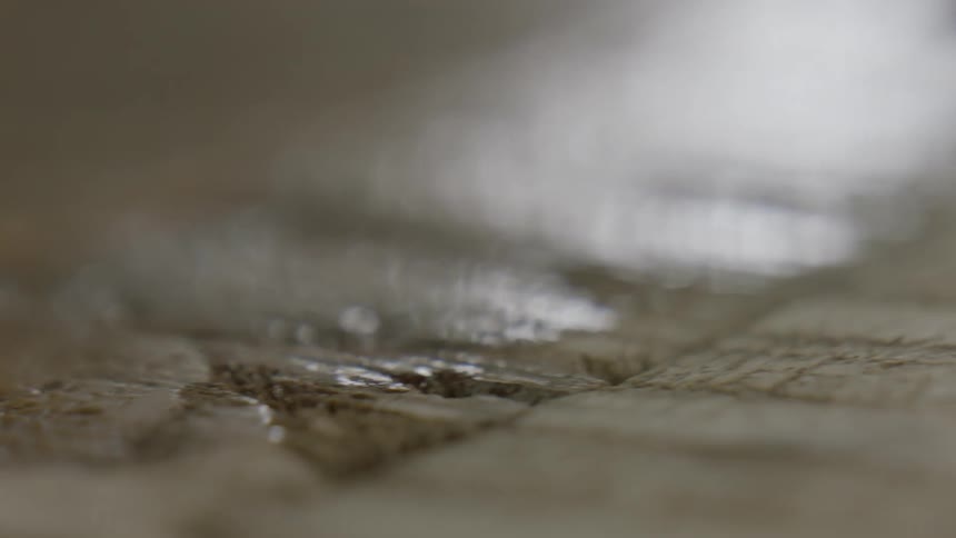 Liquid being applied to wood via a paintbrush