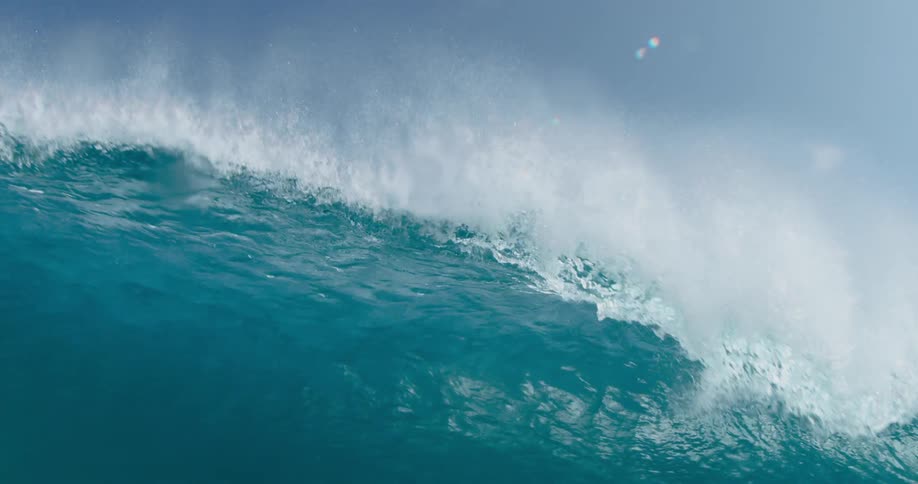 A large ocean wave curls and crashes down with enormous force