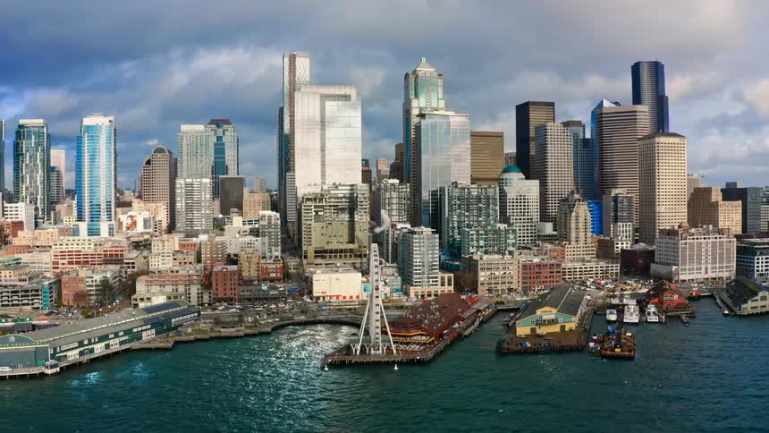 Skyscrapers near a harbor with boats on a cloudy day