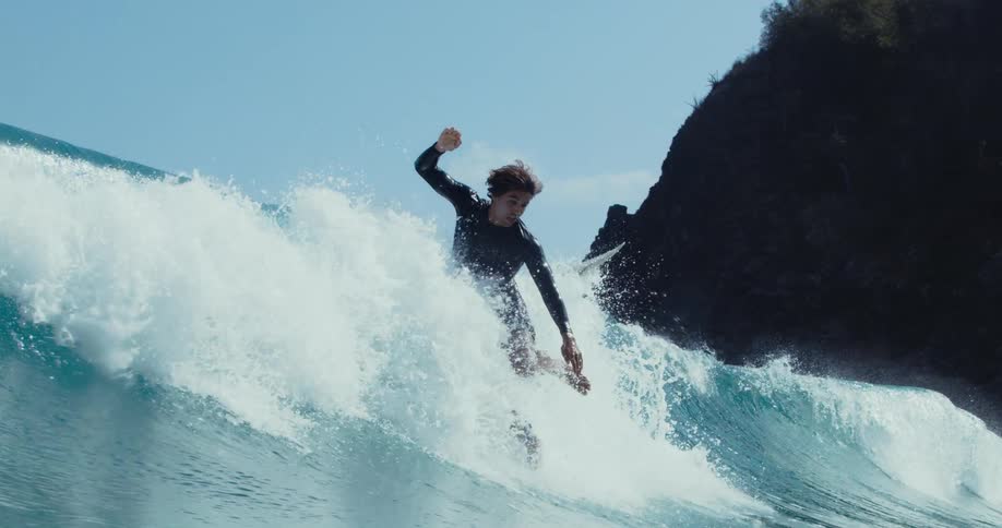 A surfer wipes out while trying to surf a big blue wave