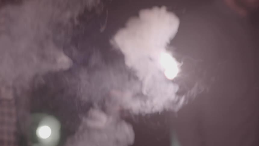 A flare is set off in a dark area and waved around