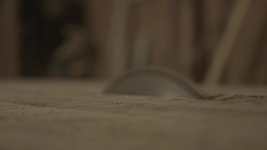 A saw is cutting through some wood