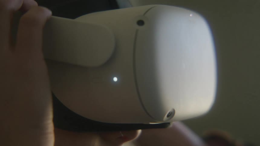 A woman puts on and adjusts a virtual reality headset