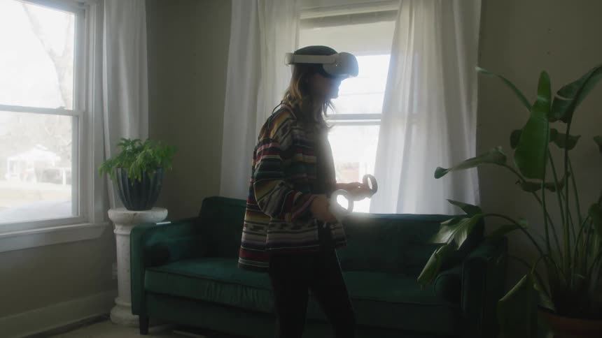 A woman using a virtual reality headset in a living room