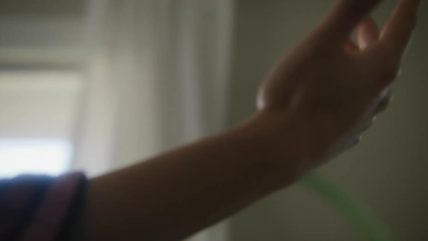 A woman tries hand tracking using a virtual reality headset indoors during the day
