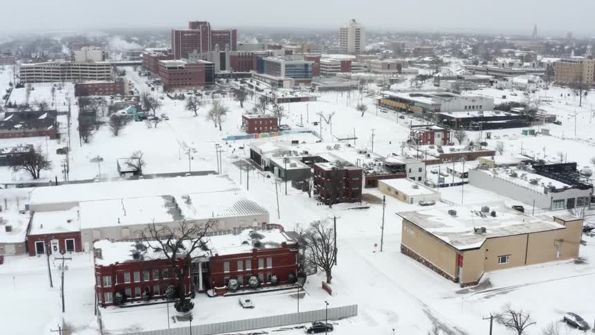 A city with a number of large buildings is coated in a thick layer of snow