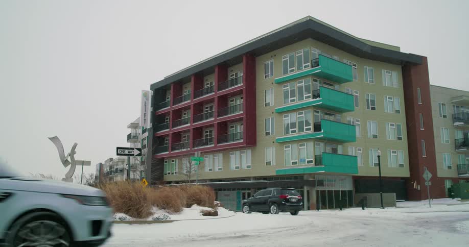 Cars drive around the road by the building