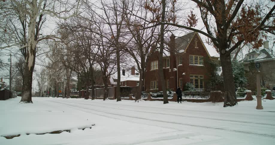 Someone is walking on a neighborhood sidewalk on a winter day