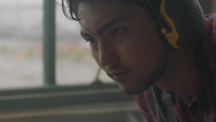 Man wearing yellow and black ear protection indoors