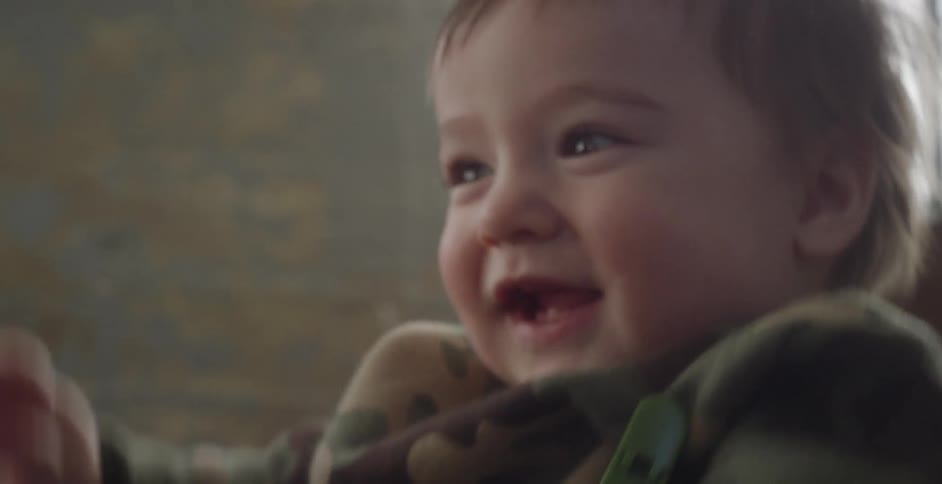 A baby laughs and jumps up and down