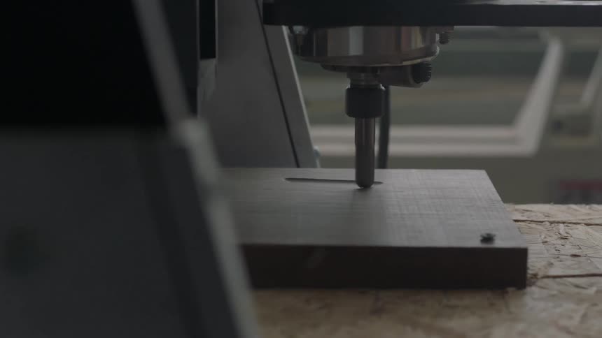 A machine is etching into wood