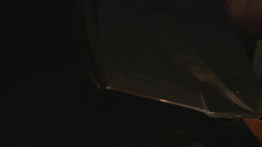 A person welds while wearing a welding mask