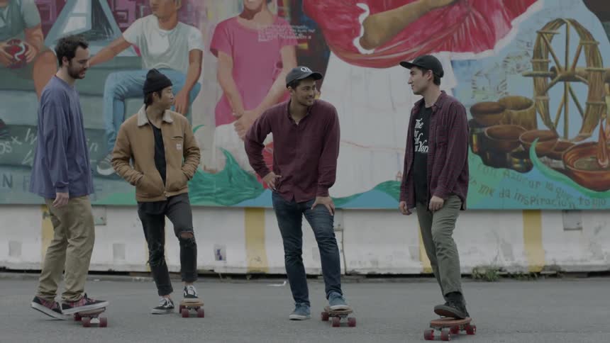 Group of men standing with their skateboards and talking