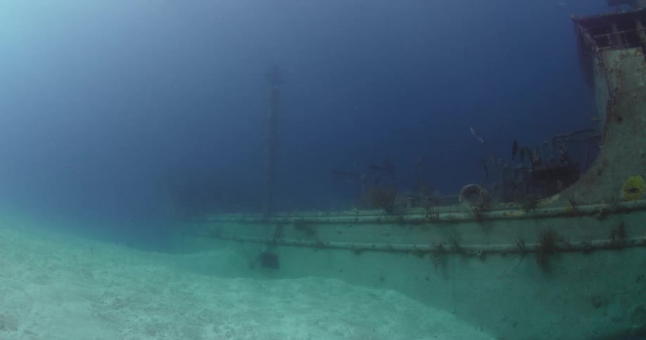 The wreckage of a large boat is located on the sandy ocean floor