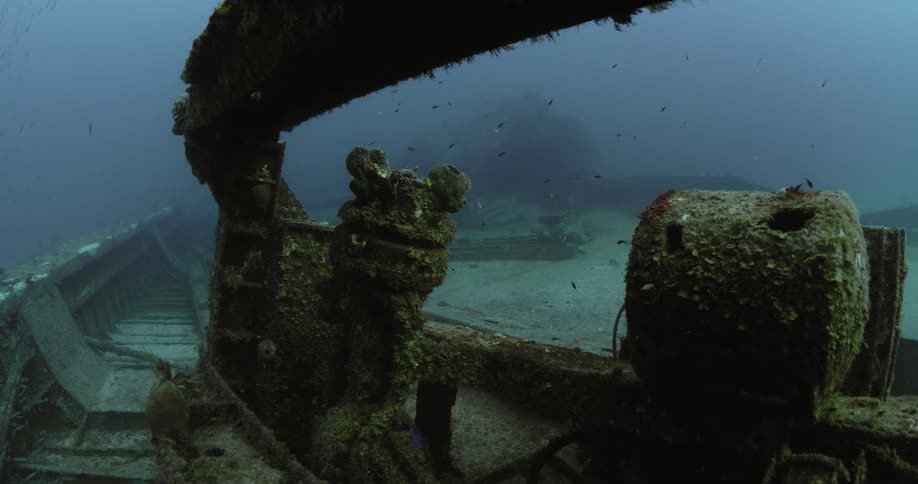 The old wreckage of a sea vessel on the floor of the sea during the day