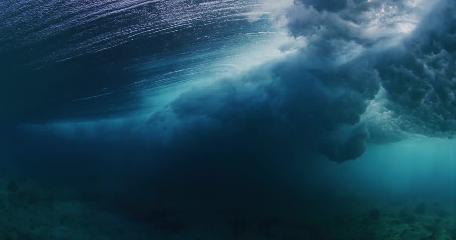 From beneath the surface of the ocean a powerful wave passes overhead