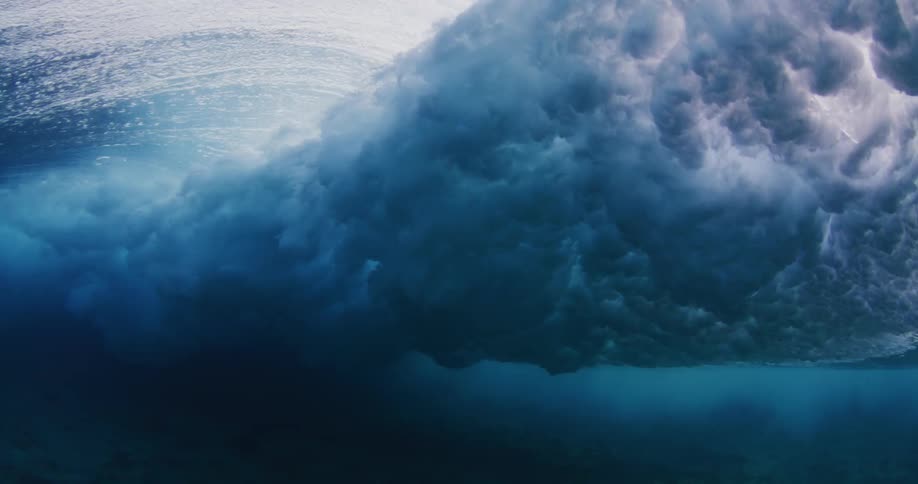 From beneath the surface of the ocean a large wave passes overhead